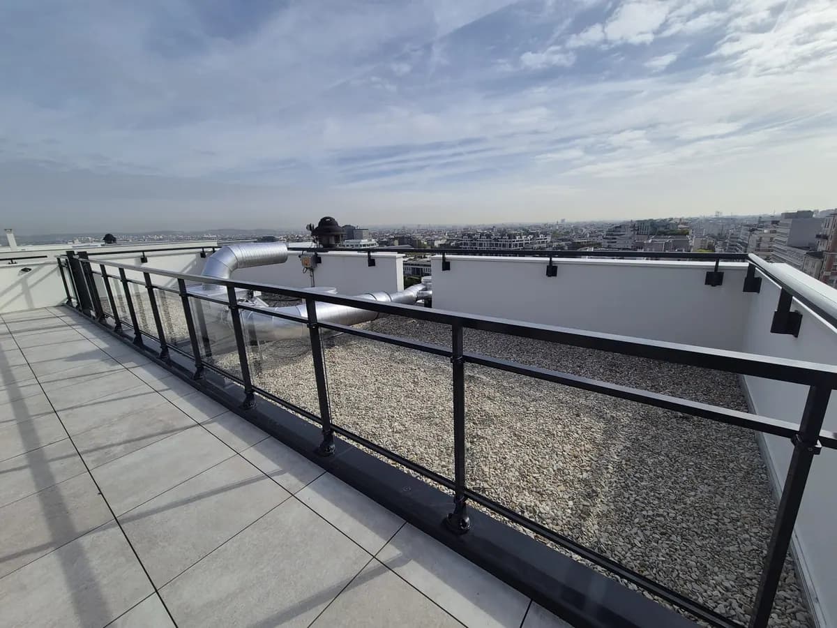 Toiture-terrasse gravillonnée et terrasse dallée avec garde-corps sur un immeuble à Courbevoie